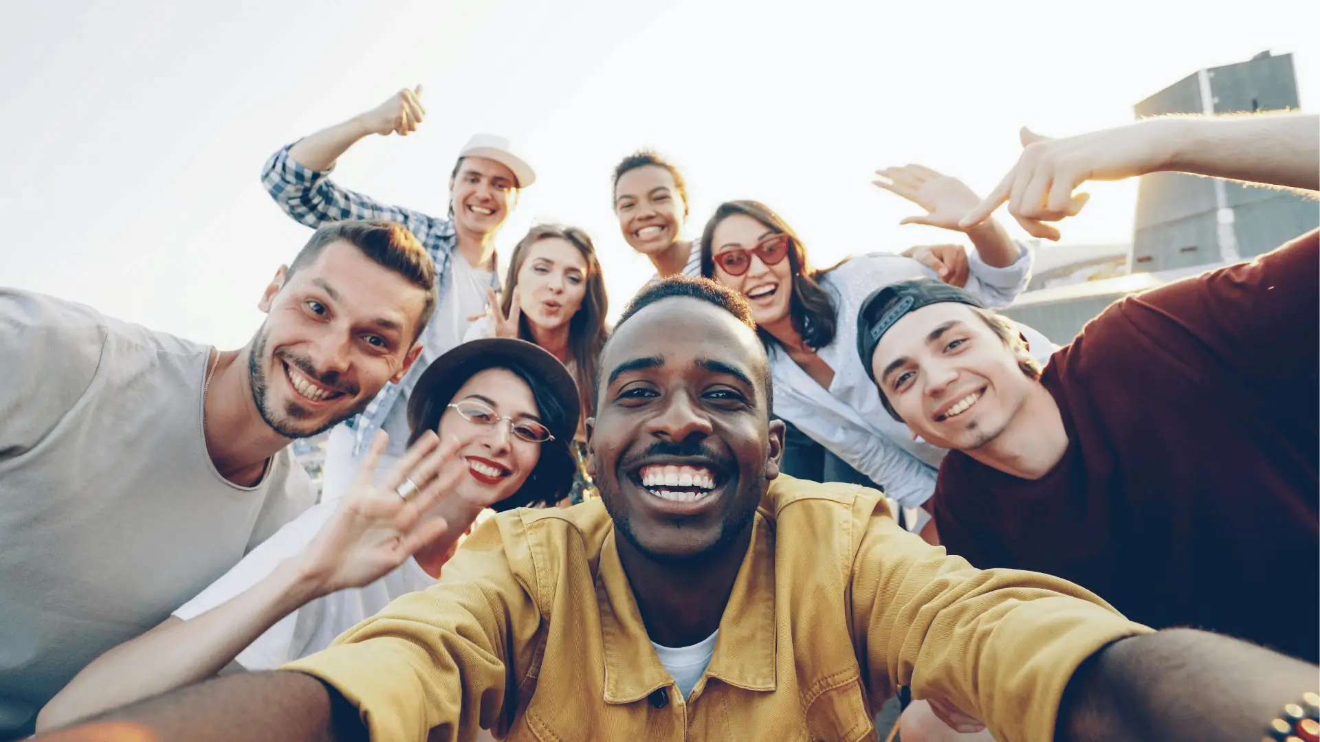 Happy team laughing while taking a rooftop selfie