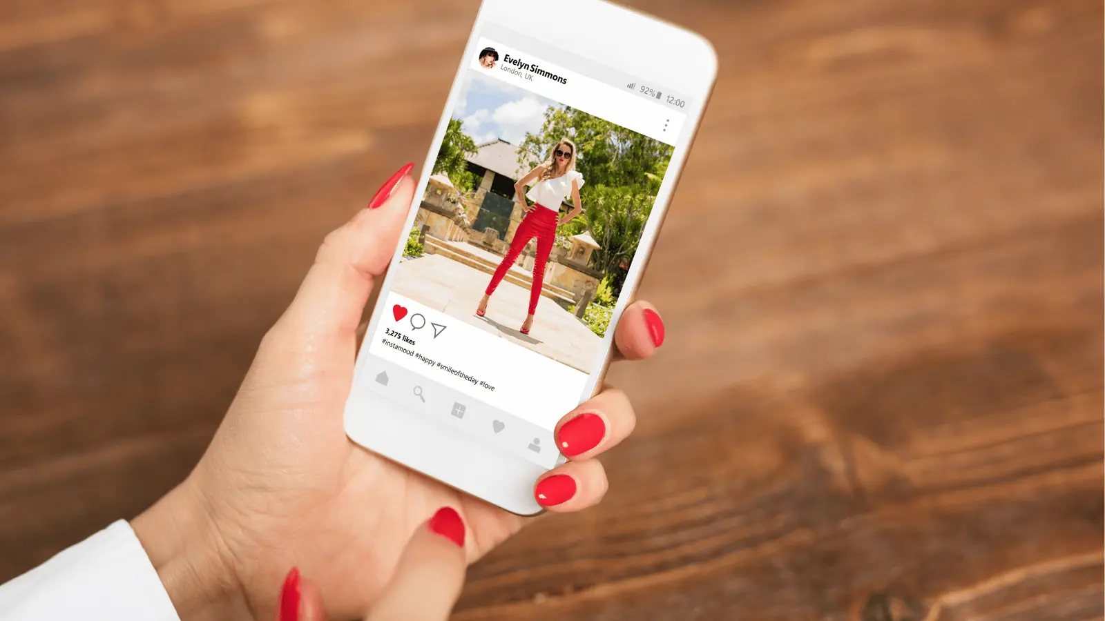 Hand holding smartphone showing an Instagram-style fashion post with red nail polish