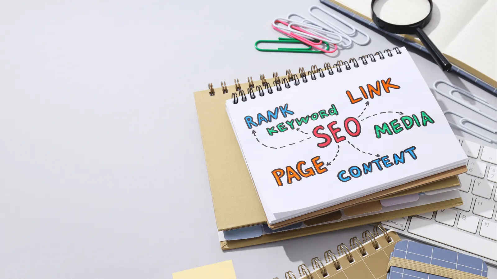Spiral notebook with colorful handwritten SEO mind map on office desk