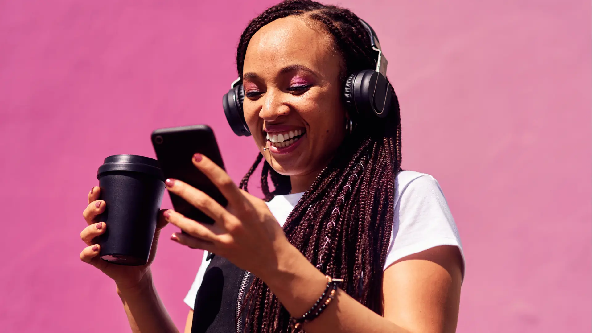 Smiling woman with headphones checking her phone